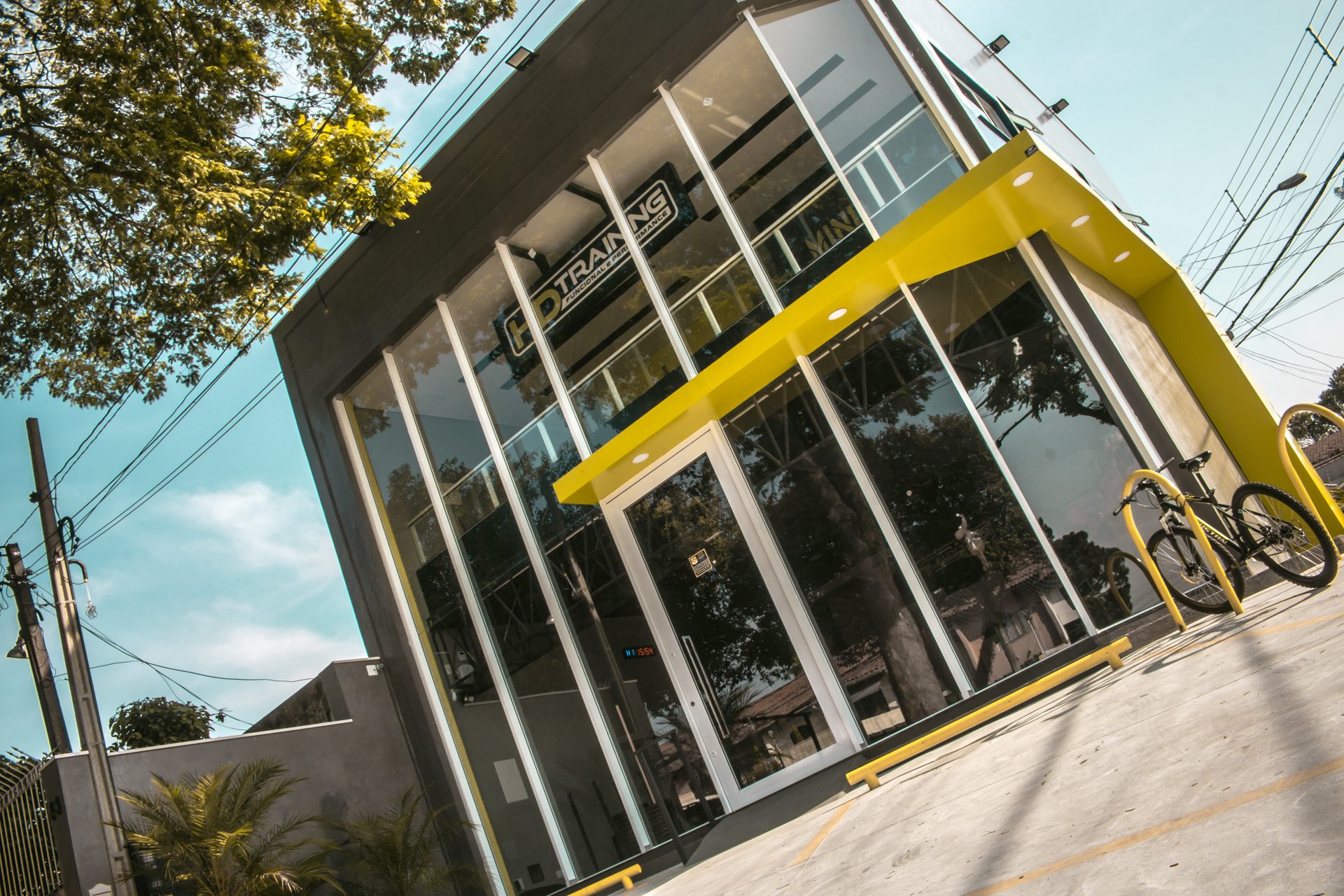 Fachada da HD Training em Interlagos, com a marquise amarela e a vitrine de vidro